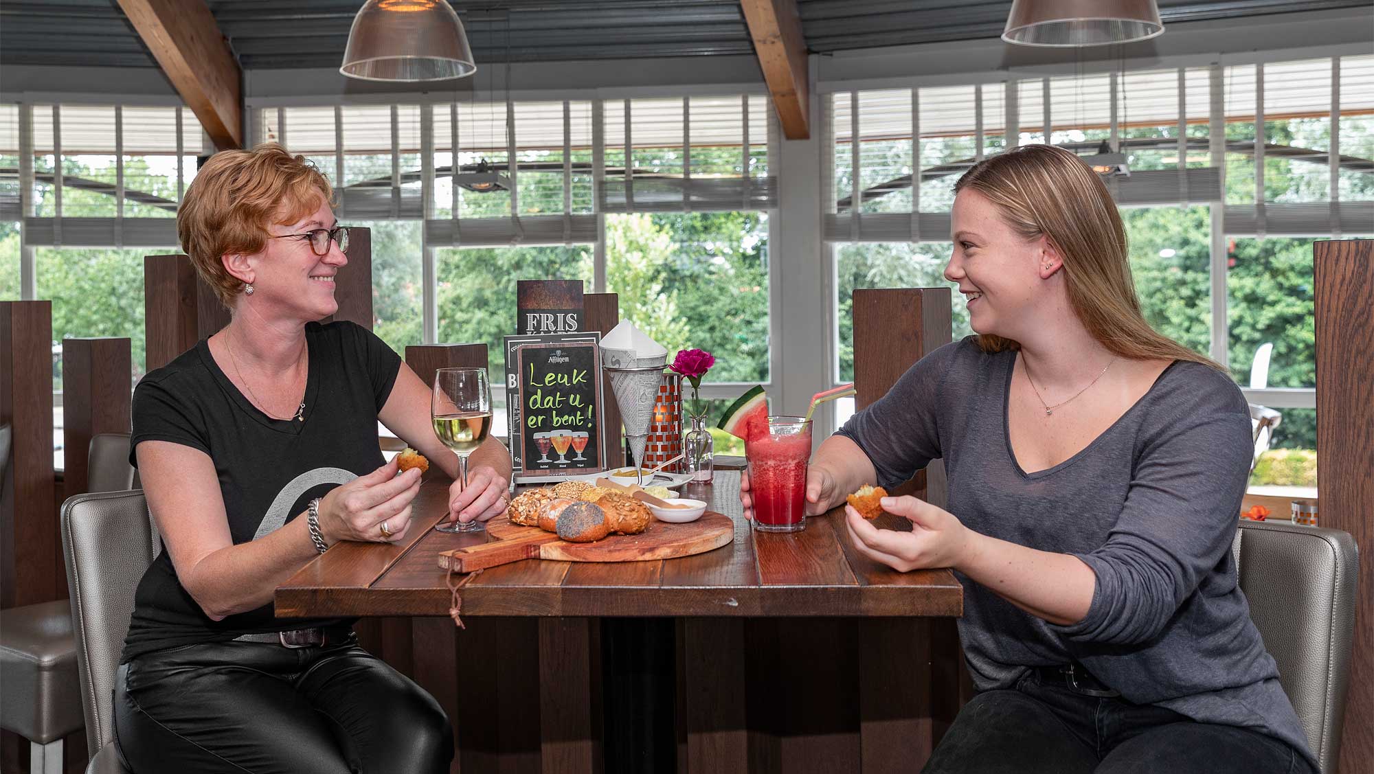 Twee vrouwen zittend aan tafel met eten